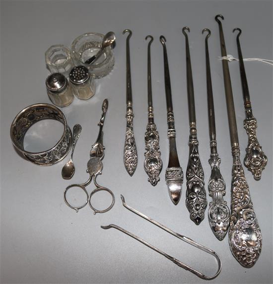 Seven silver handled button hooks and other silver items including a pair of 19th century silver sugar nips.